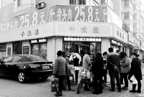 熟食店搞二月二促销 猪头当街摆吓坏中学生